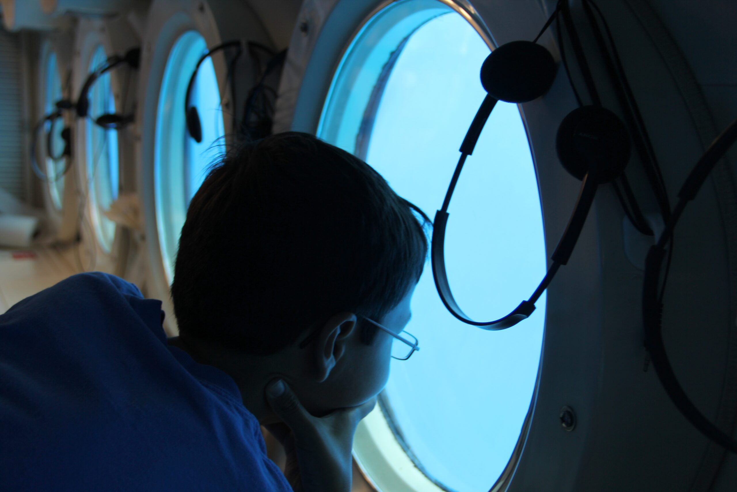 niño mirando por la escotilla de un submarino